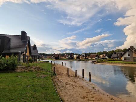 Vakantiehuizen rondom een klein meertje met strand op vakantiepark Landal Drentse Lagune