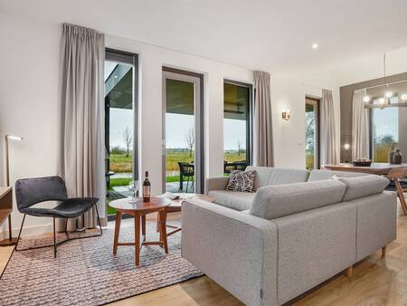 Woonkamer met grote ramen van een vakantiehuis op vakantiepark Landal Elfstedenhart