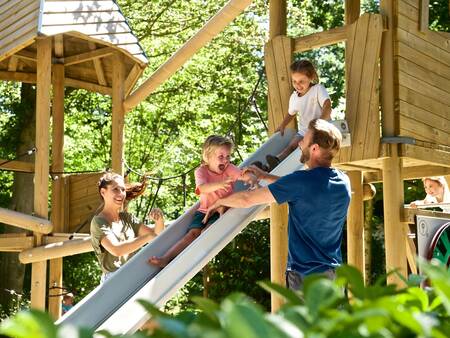 Gezin speelt in een houten speeltuin op Vakantiepark Landal Heihaas