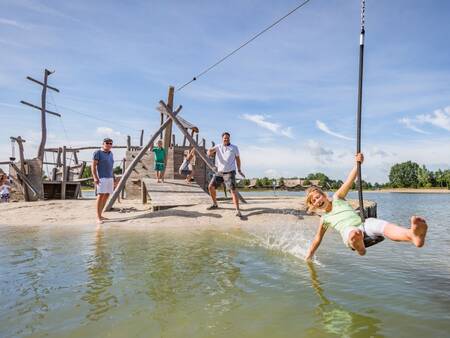 Kinderen spelen in de speeltuin bij het recreatiemeer op Landal Hof van Saksen