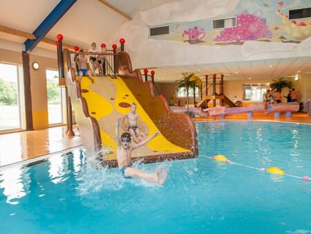 Kinderen glijden van de brede glijbaan in het zwembad op vakantiepark Landal Orveltermarke