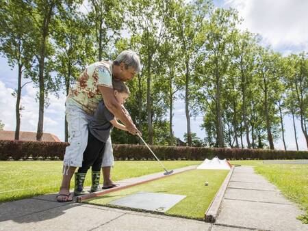 Samen midgetgolfen op de midgetgolfbaan van vakantiepark Landal Resort Haamstede