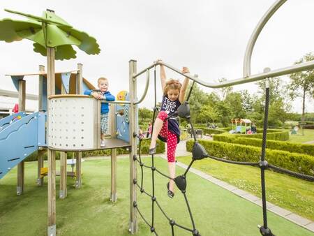 Kinderen klimmen in een speeltuin op vakantiepark Landal Resort Haamstede