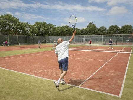 Een potje tennissen op de tennisbaan naast vakantiepark Landal Resort Haamstede