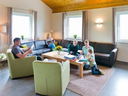 Woonkamer met gezin in een vakantiehuis op vakantiepark Landal Salztal Paradies