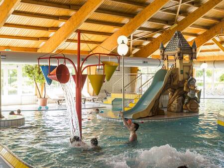 Het binnenbad met glijbaan en speeltoestellen op vakantiepark Landal Sonnenberg