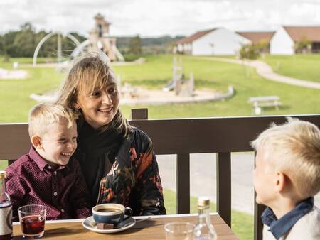 Gezin geniet van een drankje op het terras van de Brasserie op Landal Vakantiepark Søhøjlandet