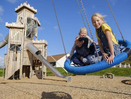 Kinderen op de schommel in de speeltuin op Landal Vakantiepark Søhøjlandet