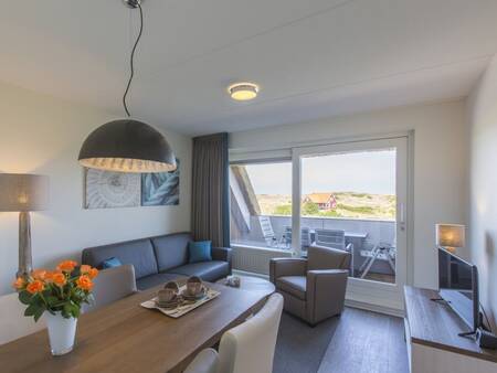 Eethoek, woonkamer en balkon van een appartement op Landal Vlieduyn