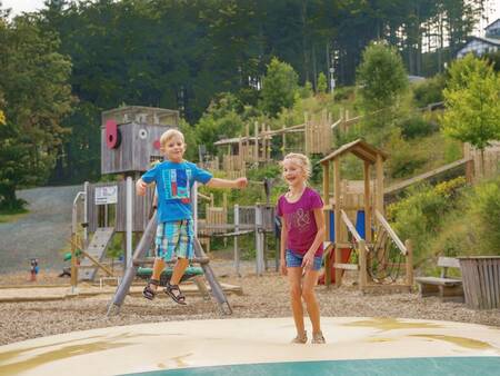 Kinderen springen op de airtrampoline in een speeltuin op vakantiepark Landal Winterberg