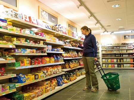 Vrouw doet boodschappen in de supermarkt van vakantiepark Landal Winterberg