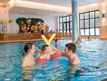 Een familie speelt in het water van het zwembad van vakantiepark Landal Winterberg