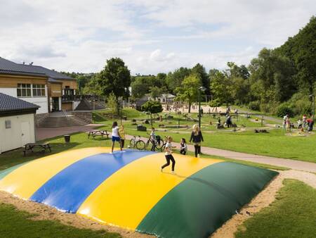 Kinderen springen op de airtrampoline in een speeltuin op vakantiepark Landal Wirfttal