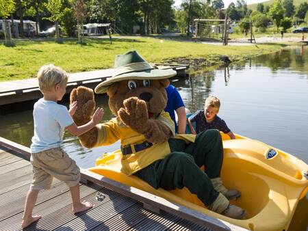 Bollo de beer en kinderen in een waterfiets op vakantiepark Landal Wirfttal