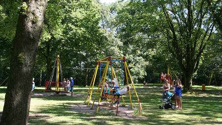 Kinderen spelen in een grote speeltuin op vakantiepark Molecaten Bosbad Hoeven