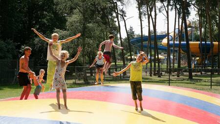 Kinderen springen op de airtrampoline in een speeltuin op vakantiepark Molecaten Bosbad Hoeven