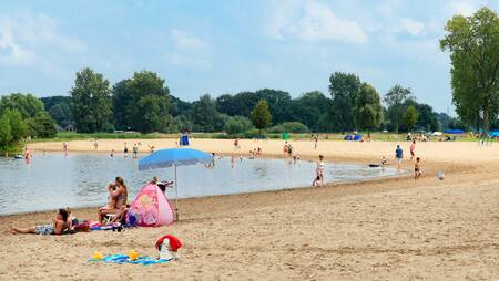 Mensen op het strand aan de Agnietenplas bij vakantiepark Molecaten Park De Agnietenberg