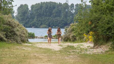 Twee vrouwen wandelen bij het Brielse meer op vakantiepark Molecaten Park Kruininger Gors