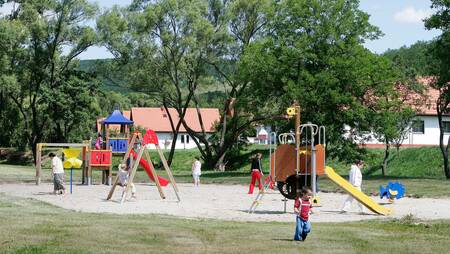 Kinderen spelen in de speeltuin van het kleinschalige vakantiepark Molecaten Park Legénd Estate