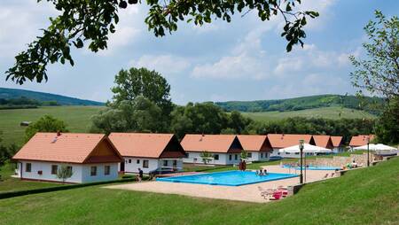 Het zwembad en vakantiehuizen op het kleinschalige vakantiepark Molecaten Park Legénd Estate
