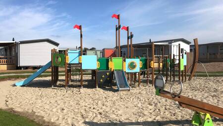 Een speeltuin tussen de chalets op vakantiepark Molecaten Park Noordduinen