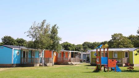 Chalets van het type "Zomerzon" op een veldje met een speeltuin op vakantiepark Molecaten Waterbos