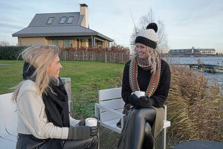 Twee vrouwen in de tuin van een luxe villa op vakantiepark Oesterdam Resort