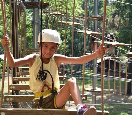 Meisje aan het klimmen in het klimbos NuNature bij vakantiepark Ommerland