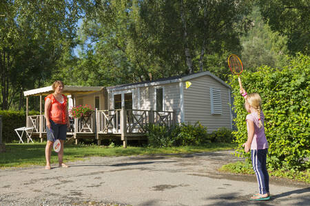 Moeder en dochter aan het badmintonnen voor een mobil home op vakantiepark RCN Belledonne