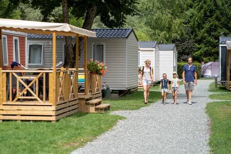 Een gezin wandelt over een pad tussen mobil homes op vakantiepark RCN Belledonne