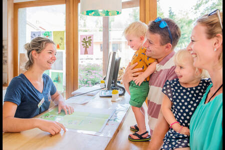 Gezin bij de receptie van vakantiepark RCN Belledonne