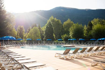 Ligstoelen rondom het buitenbad van vakantiepark RCN Belledonne