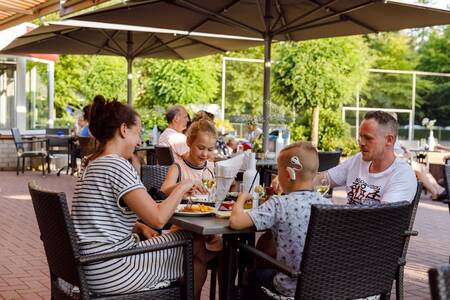 Gezin eet op het terras van Brasserie de Jagerstee op vakantiepark RCN de Jagerstee