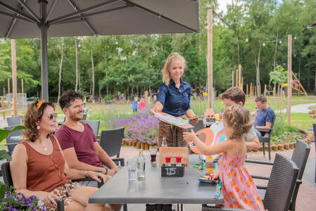 Gezin op het terras bij het restaurant  op vakantiepark RCN de Jagerstee