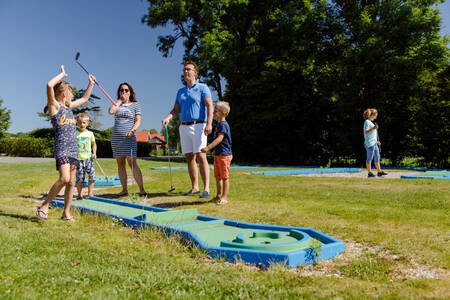 Gezin aan het golfen op de minigolfbaan van vakantiepark RCN de Potten