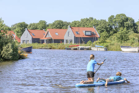 Twee kinderen aan het suppen op het water bij vakantiepark RCN de Potten