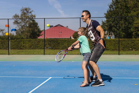 Vader met dochter aan het tennissen op de tennisbaan van vakantiepark RCN de Potten