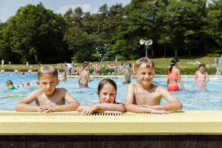 Mensen aan het zwemmen in het buitenbad van vakantiepark RCN de Roggeberg