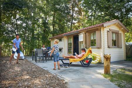 Gezin in de tuin van een chalet op vakantiepark RCN de Schotsman