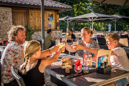 Gezin op het terras van bistro "les Saveurs" op vakantiepark RCN La Bastide en Ardèche