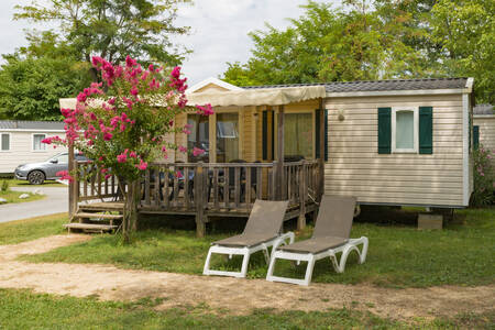 Een mobil home met overdekte veranda en ligstoelen op vakantiepark RCN La Bastide en Ardèche