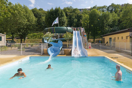 Mensen in het buitenbad met 2 glijbanen op vakantiepark RCN La Bastide en Ardèche