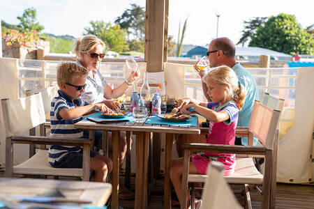 Gezin aan het eten op het terras van het restaurant op vakantiepark RCN Port l’Epine
