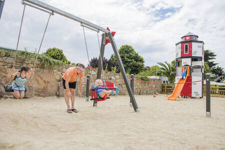 Kinderen op de schommel in de speeltuin op vakantiepark RCN Port l’Epine