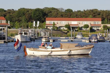 Mensen varen in een sloep in de jachthaven van vakantiepark Resort Boschmolenplas