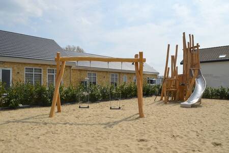 Speeltuin met schommels en klimtoestel met glijbaan op vakantiepark Resort mooi Bemelen