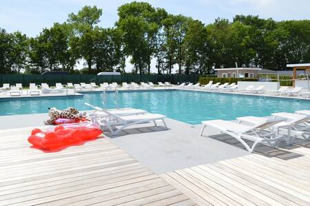 Ligstoelen rondom het buitenbad van vakantiepark Resort mooi Bemelen in Zuid-Limburg