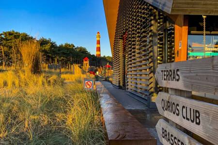 Centrumgebouw met op de achtergrond de speeltuin op vakantiepark Roompot Ameland