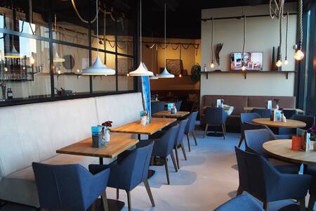 Tafels met stoelen in het sfeervolle restaurant van Roompot Bloemendaal aan Zee
