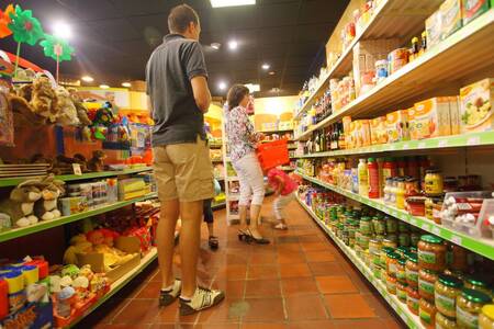 Mensen aan het winkelen in de supermarkt van vakantiepark Roompot Bospark de Schaapskooi